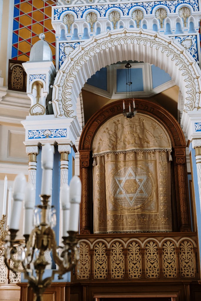 Intricate interior of a synagogue featuring a decorated Torah ark and Star of David.
