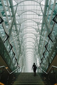 Stunning vertical shot of a modern atrium with a person ascending the staircase in Toronto's iconic Brookfield Place.