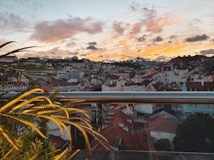Vibrant cityscape of Lisbon at sunset with picturesque rooftops and colorful sky.